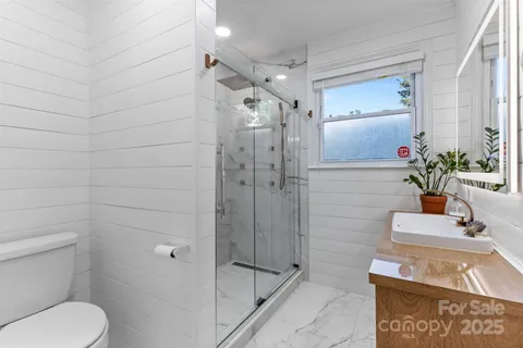 a bathroom with a shower a toilet and sink