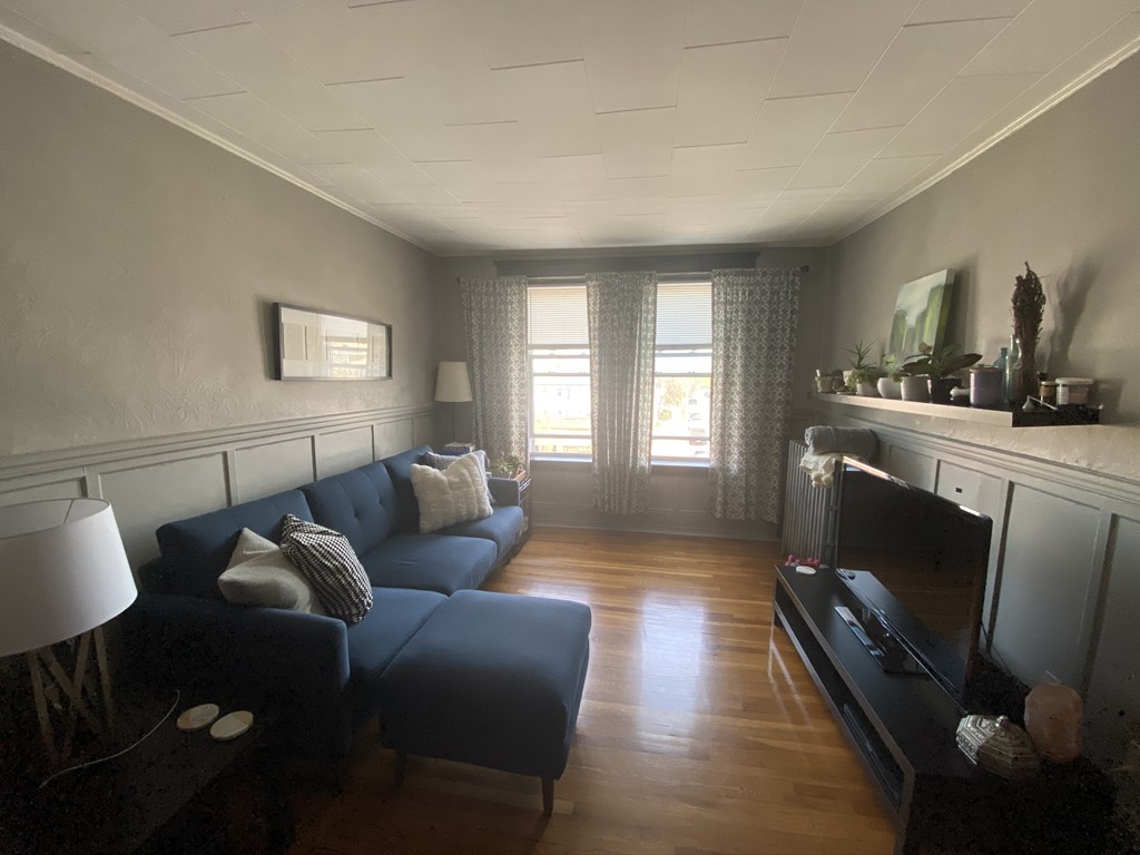136 Broadway, Unit 3 Somerville, MA 02145 - Photo 11 of 11 a living room with furniture window and wooden floor
