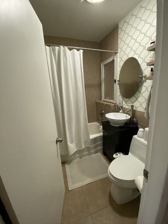 136 Broadway, Unit 3 Somerville, MA 02145 - Photo 3 of 11 a bathroom with a toilet sink and tub