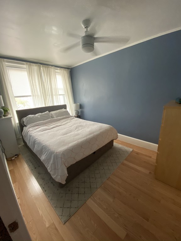 136 Broadway, Unit 3 Somerville, MA 02145 - Photo 4 of 11 a bedroom with a bed and window