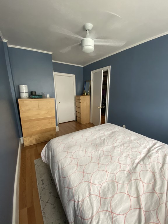 136 Broadway, Unit 3 Somerville, MA 02145 - Photo 5 of 11 a bedroom with a bed and a refrigerator
