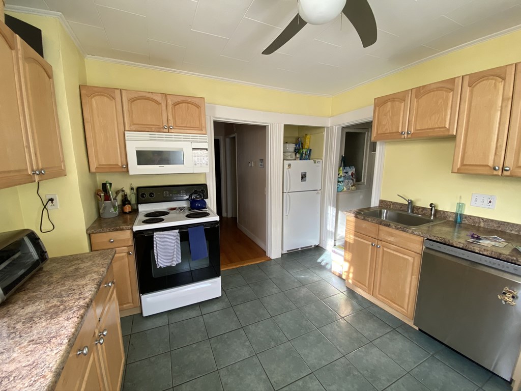 136 Broadway, Unit 3 Somerville, MA 02145 - Photo 10 of 11 a kitchen with stainless steel appliances granite countertop a stove and a sink
