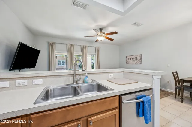 a kitchen with a sink and a flat screen tv