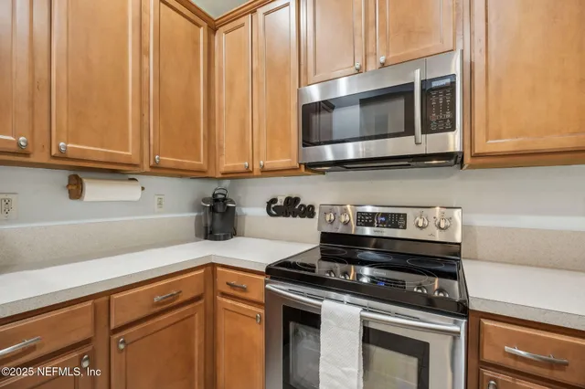 a kitchen with stainless steel appliances granite countertop a stove and a microwave