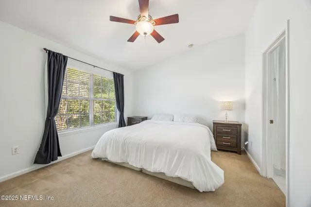 a bedroom with a bed and a large window