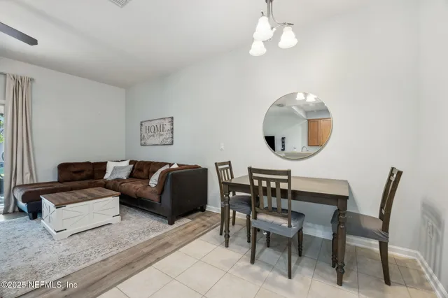 a living room with furniture a mirror and a large window