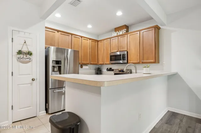a kitchen with stainless steel appliances a refrigerator sink and microwave