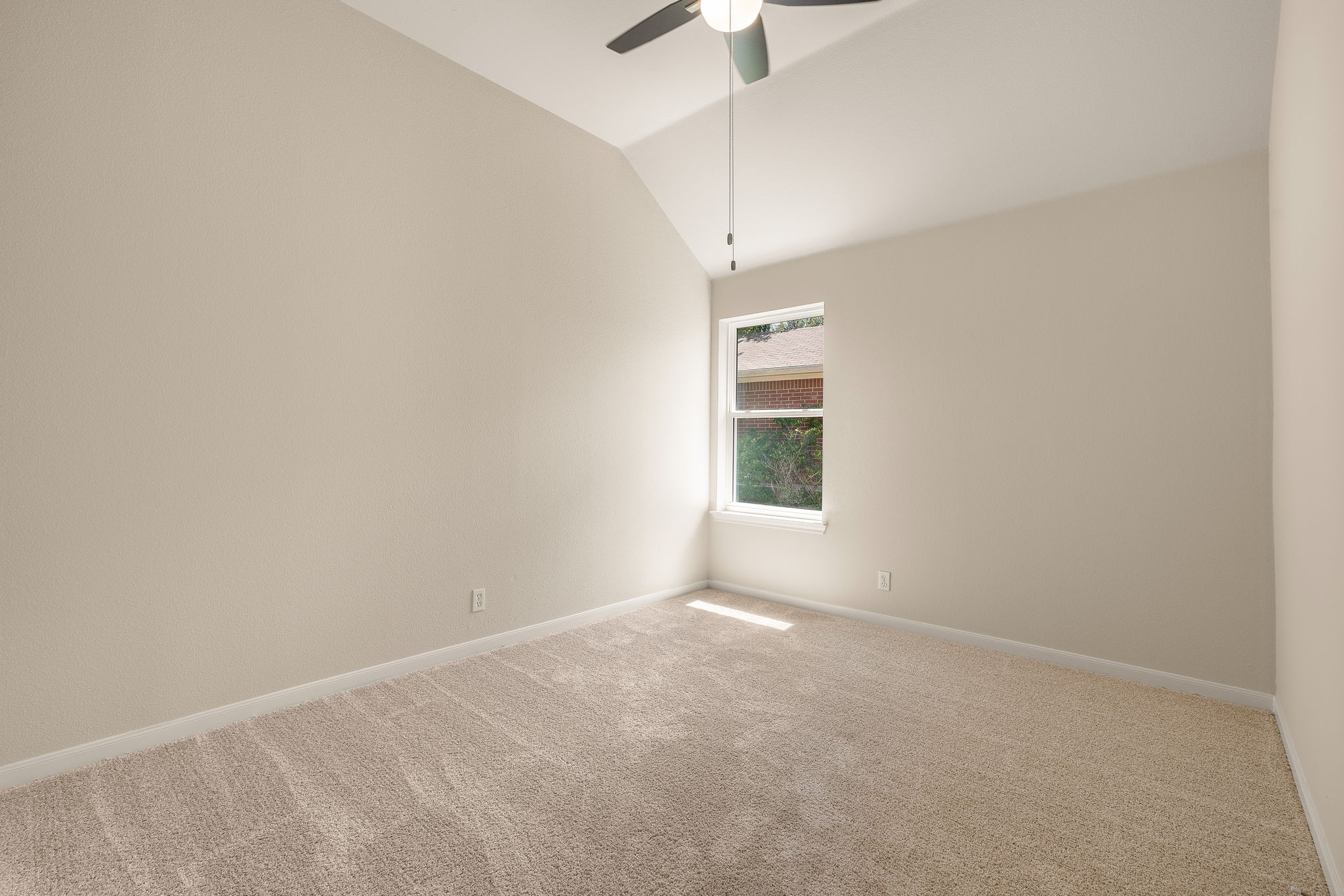 1100 Springbrook Road Pflugerville, TX 78660 - Photo 16 of 23 A well-lit bedroom with vaulted ceilings and a single window, providing a serene personal retreat.