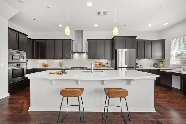 a kitchen with stainless steel appliances granite countertop a sink stove and cabinets