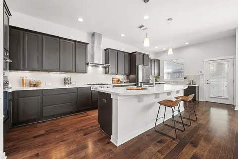 a kitchen with a sink cabinets and wooden floor