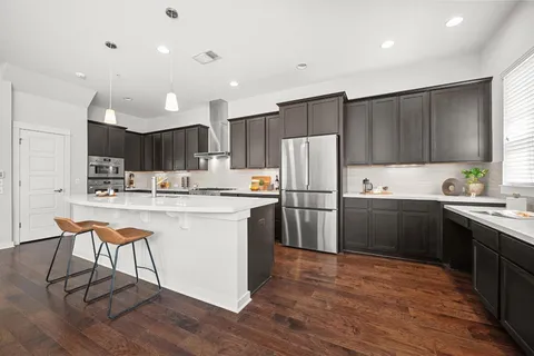 a kitchen with kitchen island granite countertop wooden cabinets and white appliances