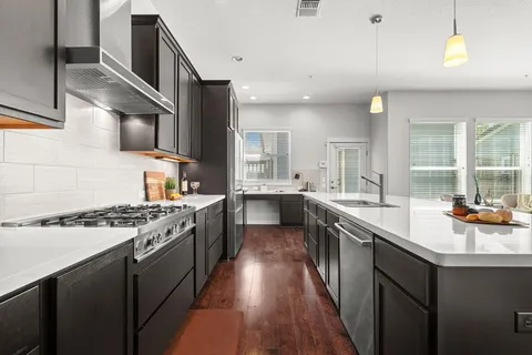 a kitchen with stainless steel appliances granite countertop a sink stove and cabinets