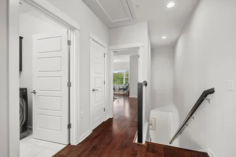 a view of a hallway with wooden floor and staircase