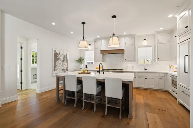 a kitchen with appliances cabinets and chair