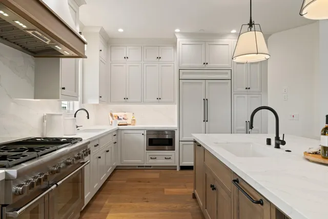 a kitchen with white cabinets a sink stove and refrigerator