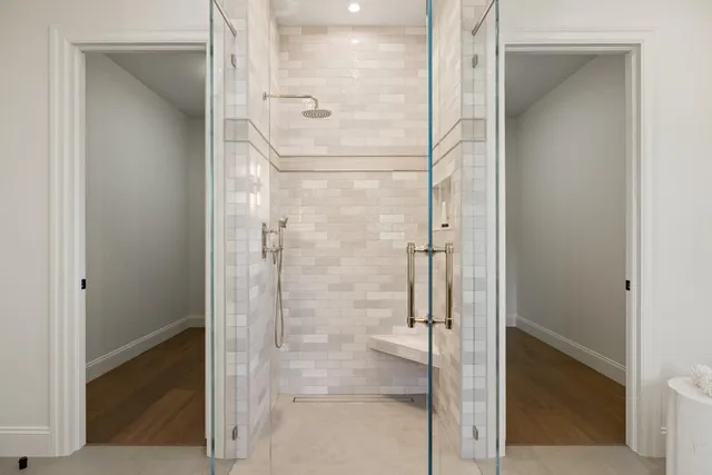 a bathroom with a glass shower door and a mirror
