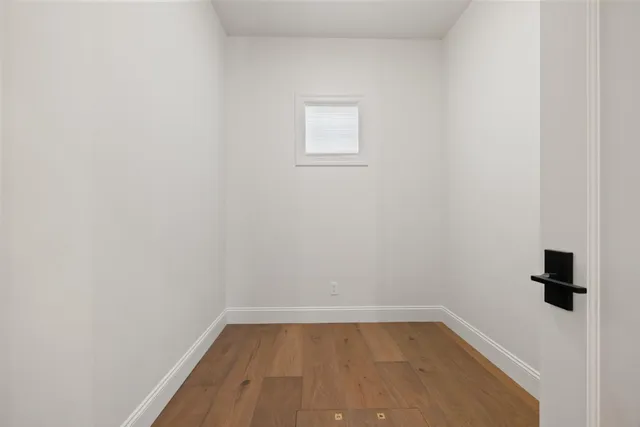 a view of a small space with wooden floor and a window