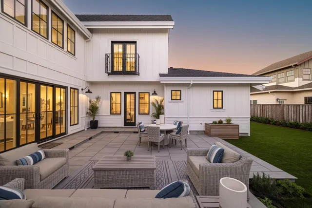 a view of a patio with couches table and chairs with garden view