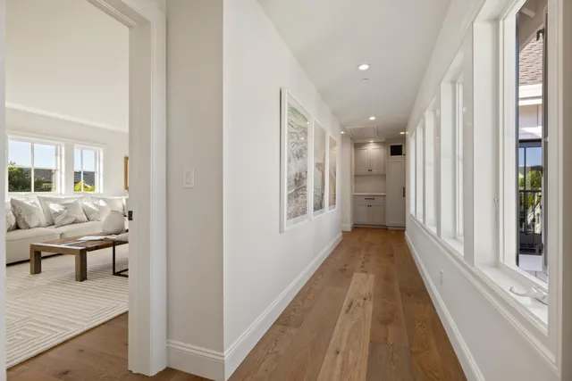 a view of a hallway with wooden floor and furniture