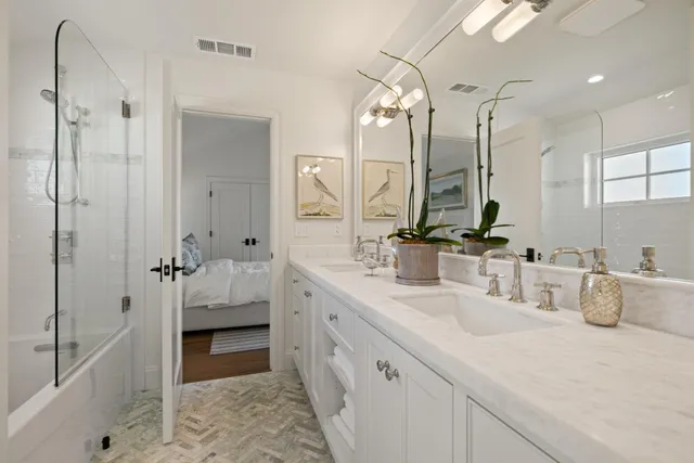 a bathroom with a double vanity sink mirror and shower