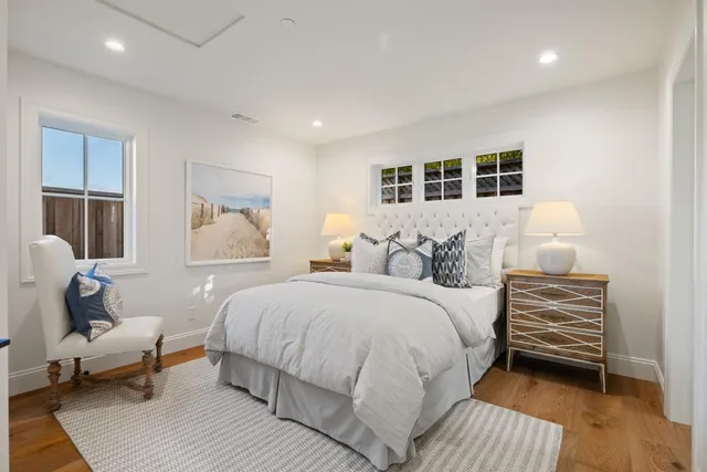 a spacious bedroom with a bed and wooden floor