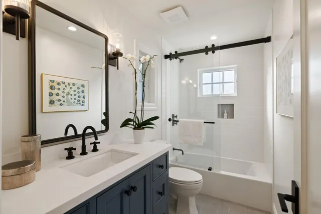 a bathroom with a double vanity sink toilet mirror and shower