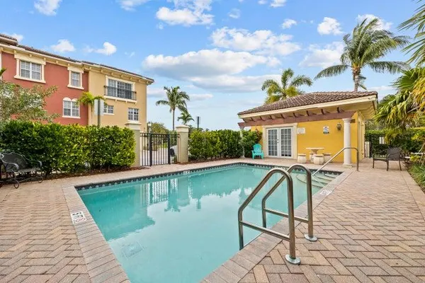 a front view of a house with swimming pool and sitting area
