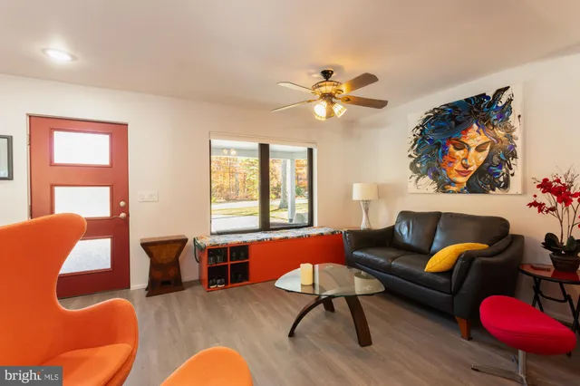 a living room with furniture kitchen view and a wooden floor