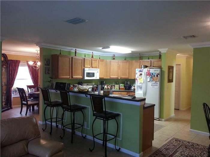 6397 Adriatic Way Greenacres, FL 33413 - Photo 24 of 29 a kitchen with a table and chairs in it