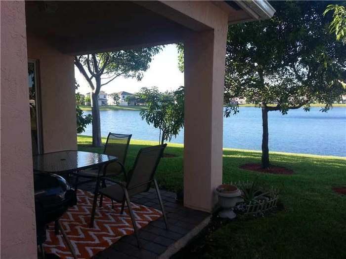 6397 Adriatic Way Greenacres, FL 33413 - Photo 29 of 29 a view of a porch with furniture and garden