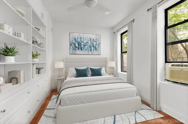 an empty room with kitchen view and wooden floor