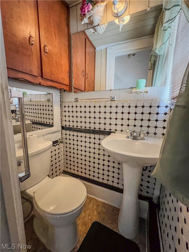 3110 Neosho Road Youngstown, OH 44511 - Photo 15 of 35 Bathroom with tile flooring, sink, toilet, tile walls, and backsplash
