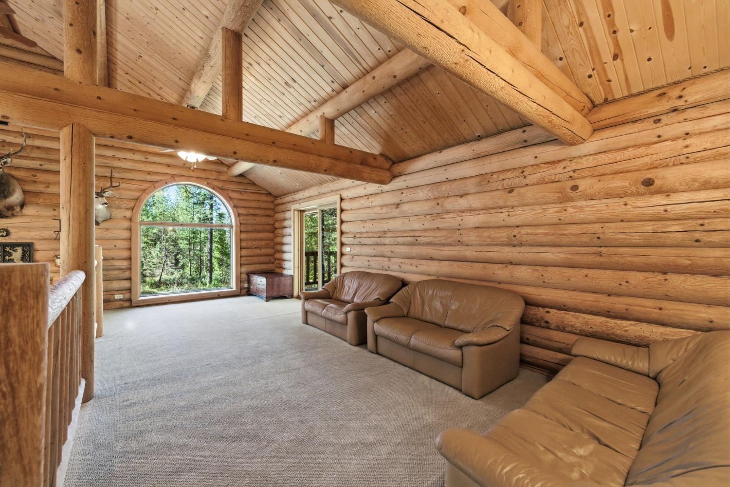 2428 Rancho Paradiso Arnold, CA 95223 - Photo 33 of 67 Expansive upper-level loft with a striking arched window and private slider to a covered deck. This versatile retreat serves perfectly as a home office, media space, or extra lounge area.