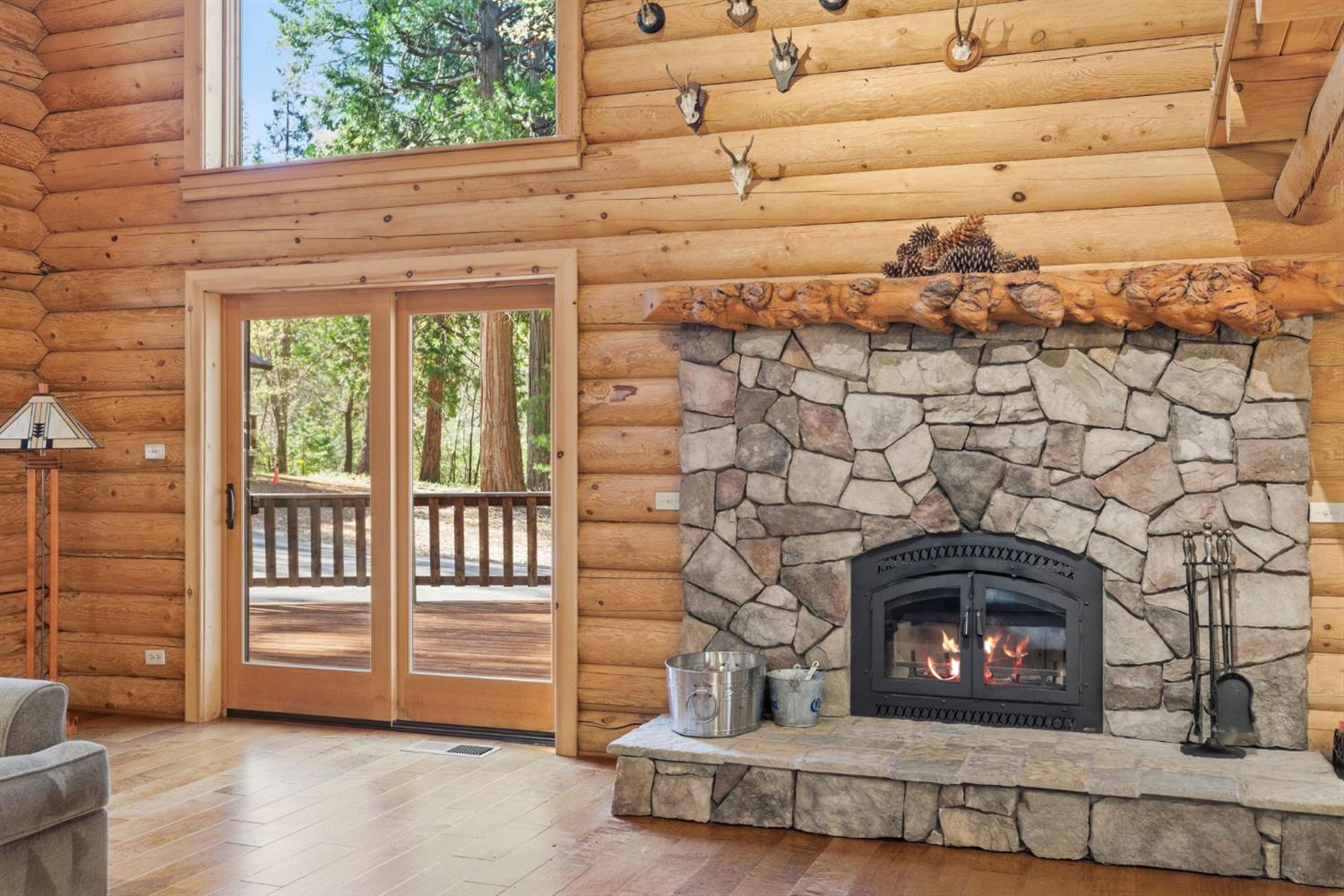 2428 Rancho Paradiso Arnold, CA 95223 - Photo 44 of 67 a living room with a fireplace and a floor to ceiling window