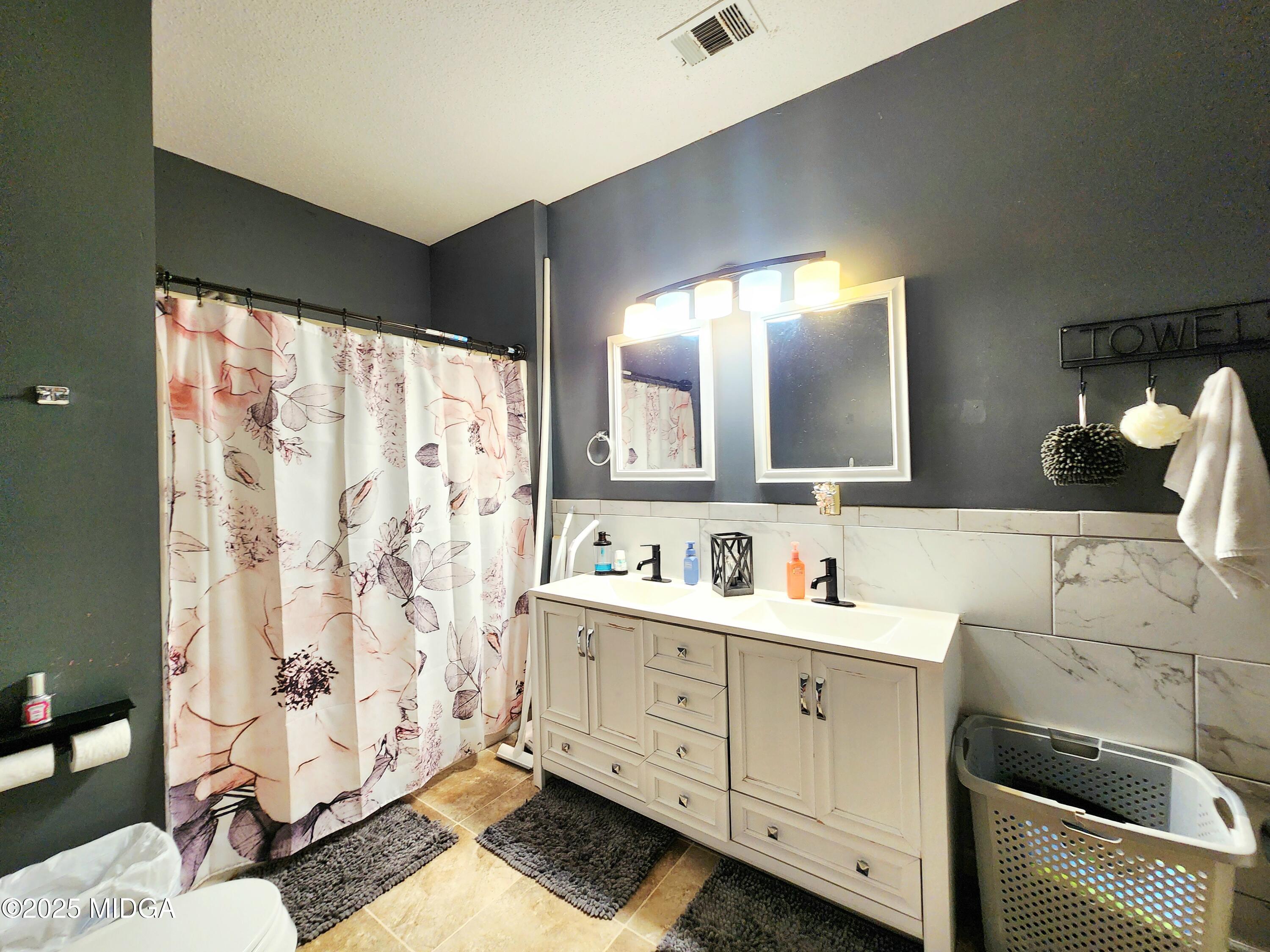 702 Carl Sutton Road Lizella, GA 31052 - Photo 23 of 43 a bathroom with a double vanity sink mirror and shower