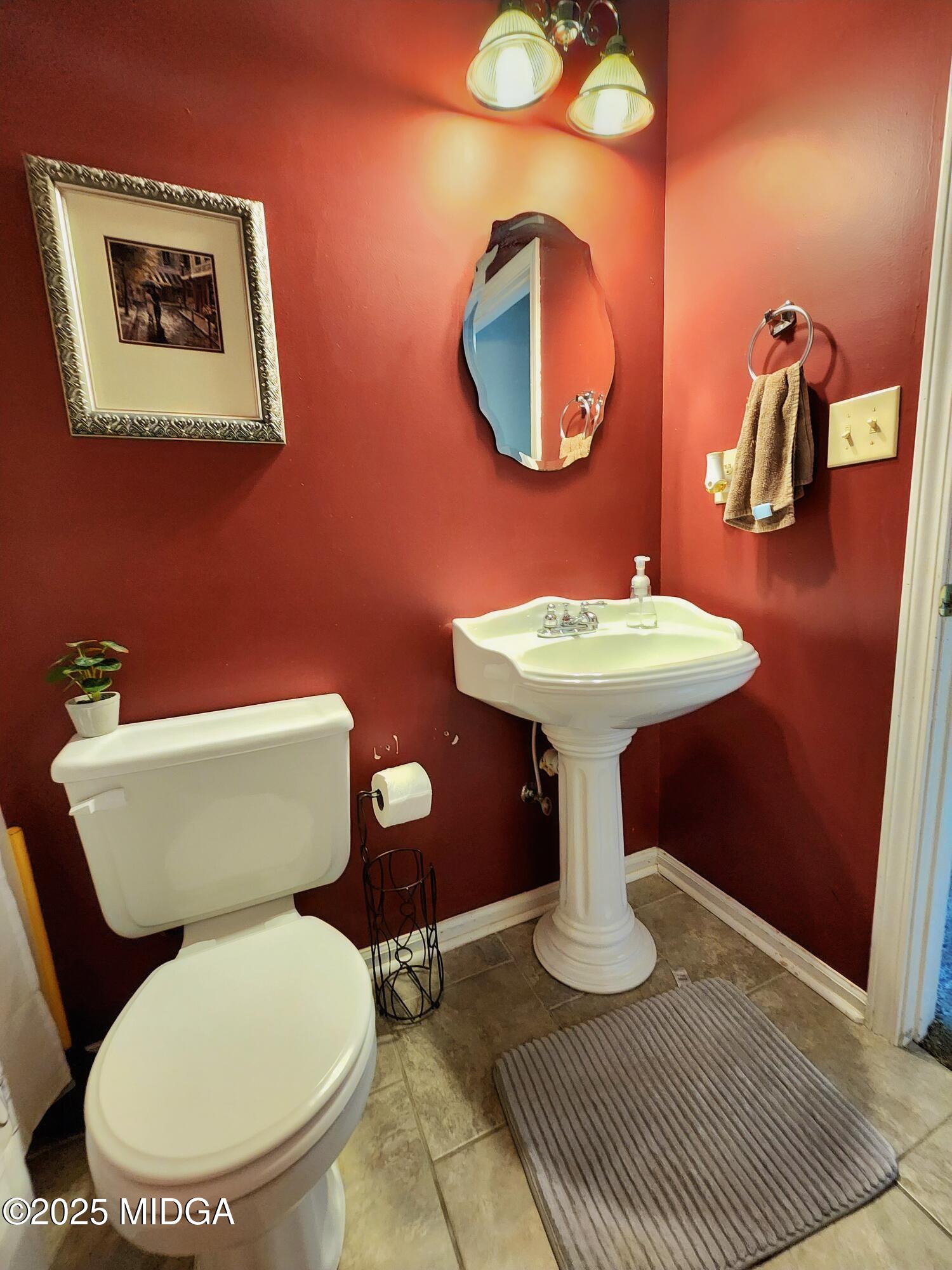 702 Carl Sutton Road Lizella, GA 31052 - Photo 33 of 43 a bathroom with a toilet a sink and mirror