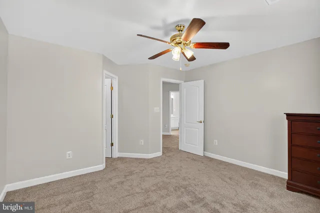 a spacious bedroom with a bed and a ceiling fan