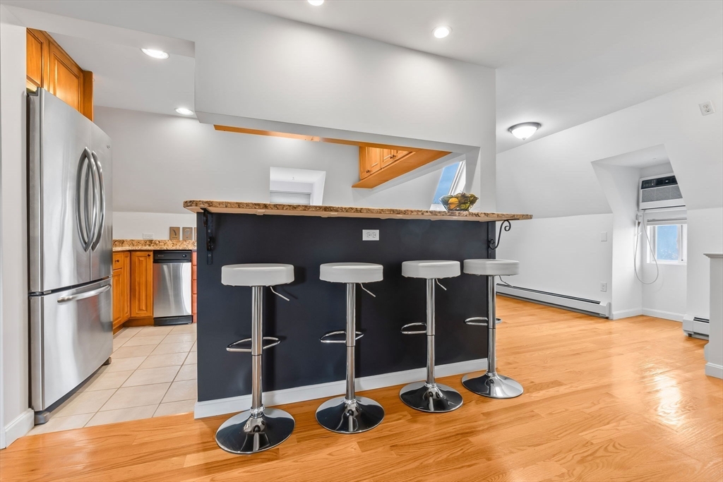 20 Ash Street, Unit 3 Danvers, MA 01923 - Photo 25 of 39 a kitchen with stainless steel appliances granite countertop a refrigerator and a stove
