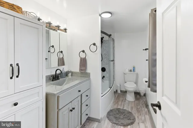 a view of a house with a small yard and a large tree