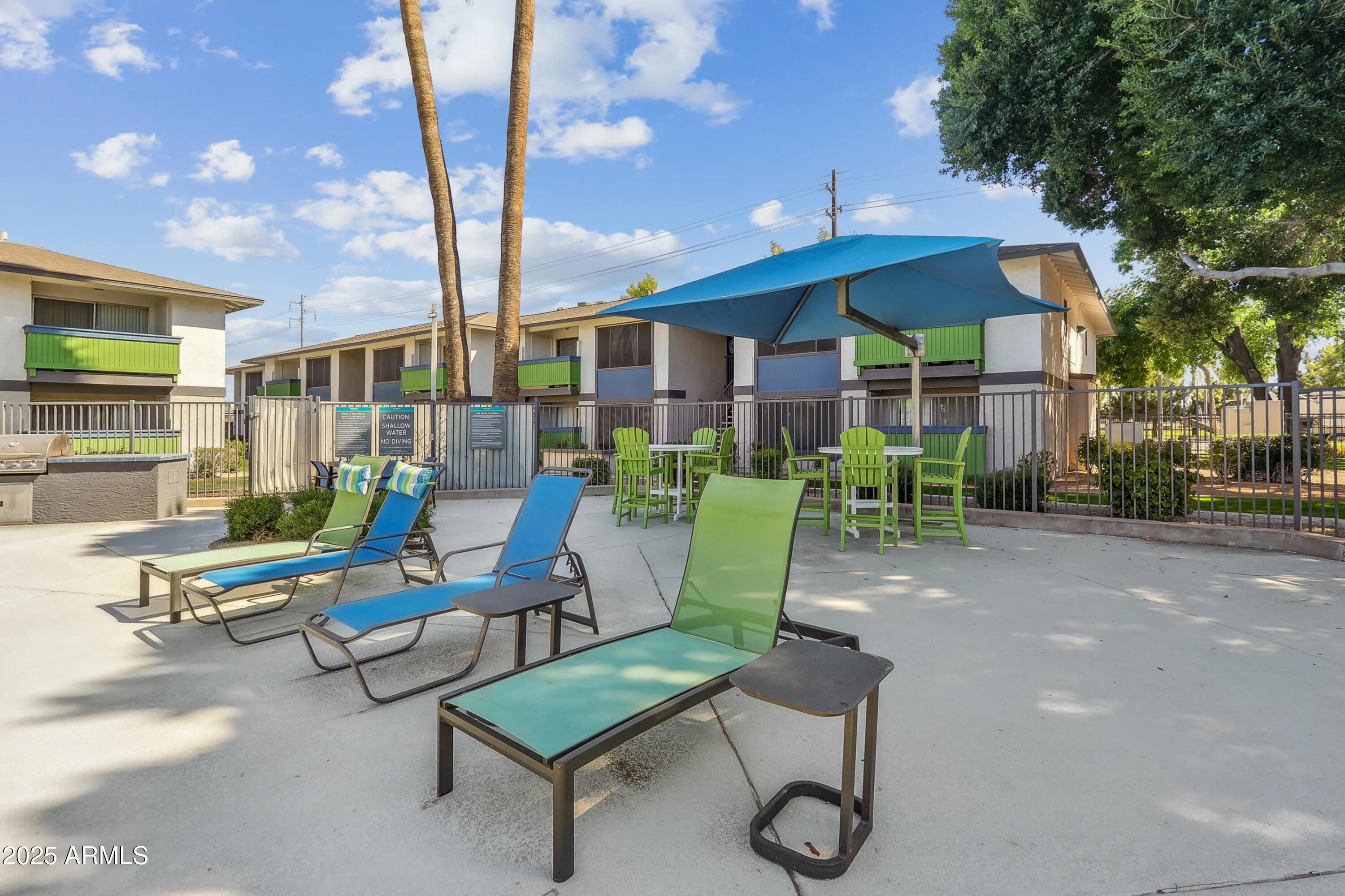 1620 West Southern Avenue, Unit S1 Mesa, AZ 85202 - Photo 12 of 15 a view of a patio with table and chairs under an umbrella with a fire pit