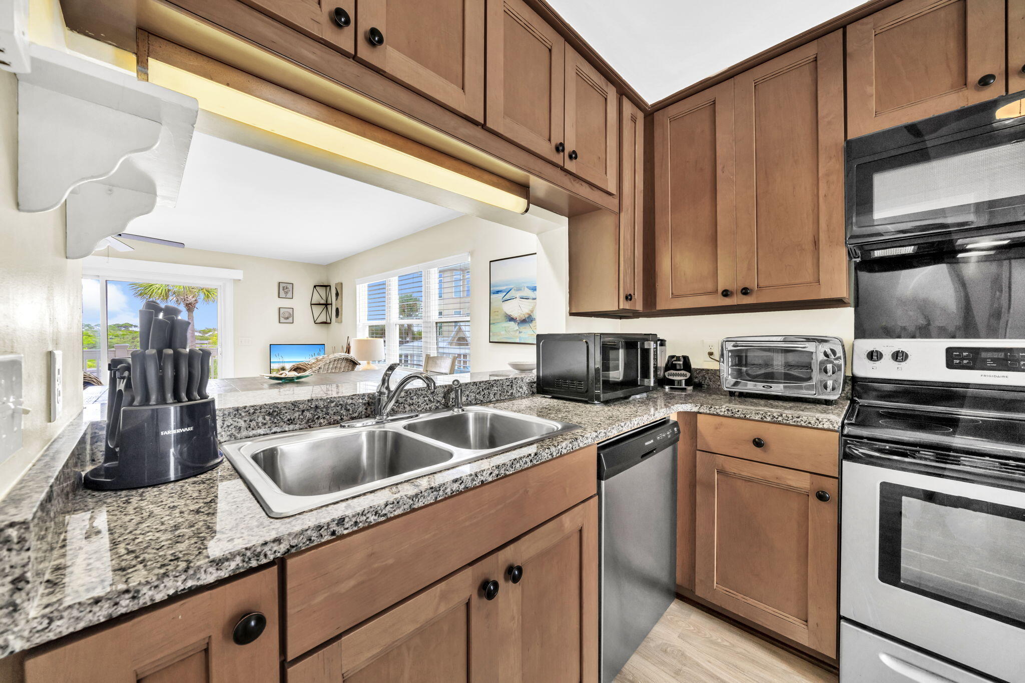 228 Walton Magnolia Lane, Unit 4 Inlet Beach, FL 32461 - Photo 6 of 45 a kitchen with granite countertop a sink stainless steel appliances wooden cabinets and a counter top space