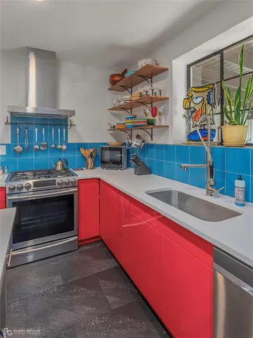 a kitchen with stainless steel appliances granite countertop a stove and a sink