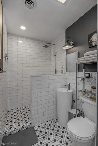 a bathroom with a toilet a sink and shower