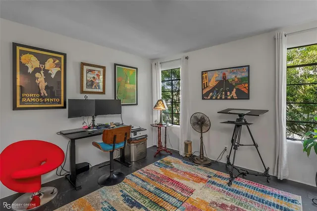 a view of a workspace with furniture and a window