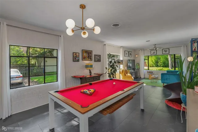 a room with pool table and windows