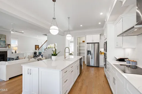 a kitchen with kitchen island white cabinets and refrigerator