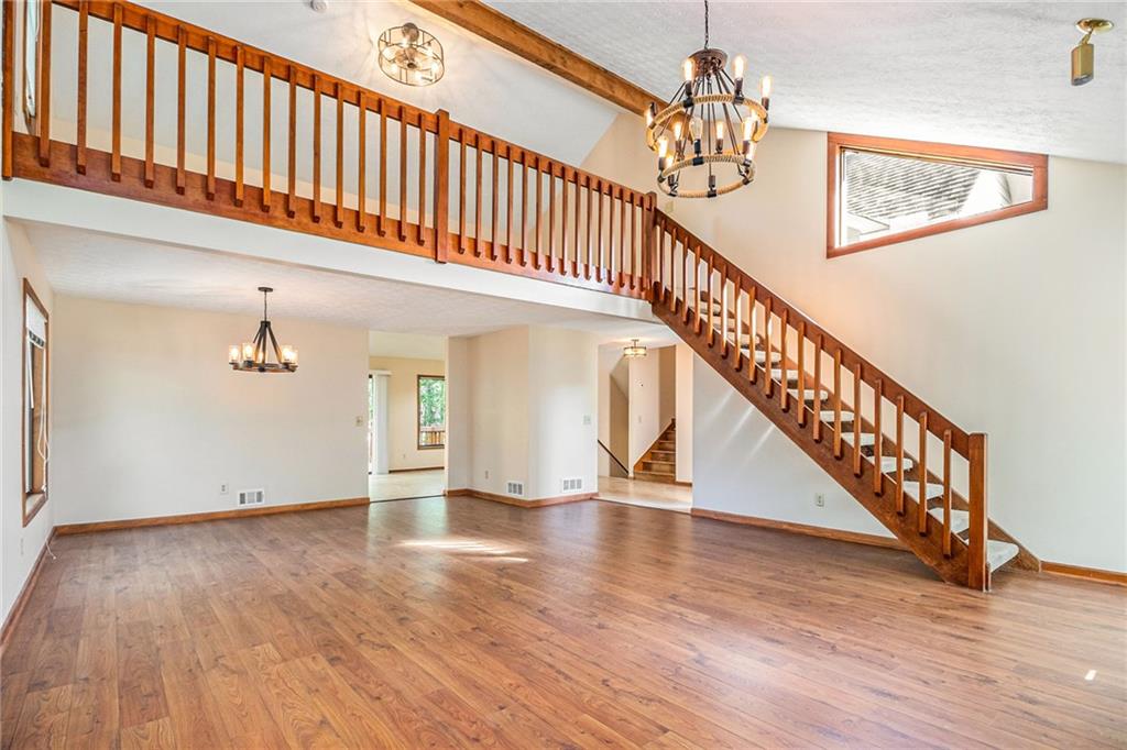 a view of staircase with wooden floor and a chandelier