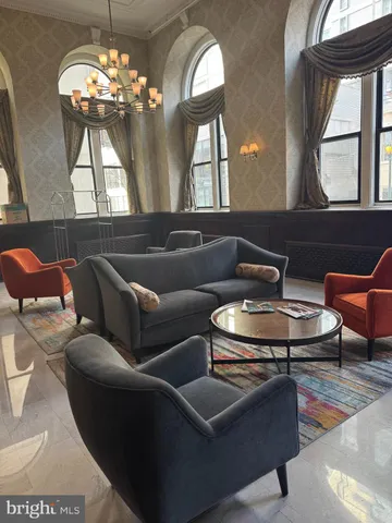 a living room with furniture a chandelier and a flat screen tv