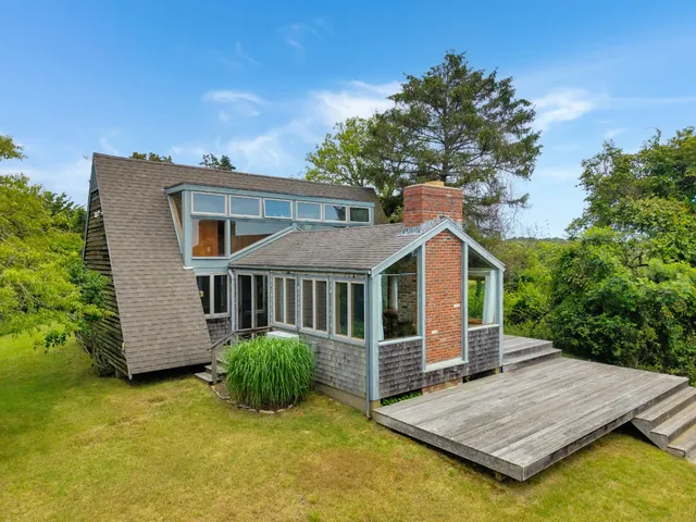 a front view of a house with a yard and potted plants