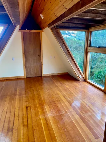 a view of a room with wooden floor and window